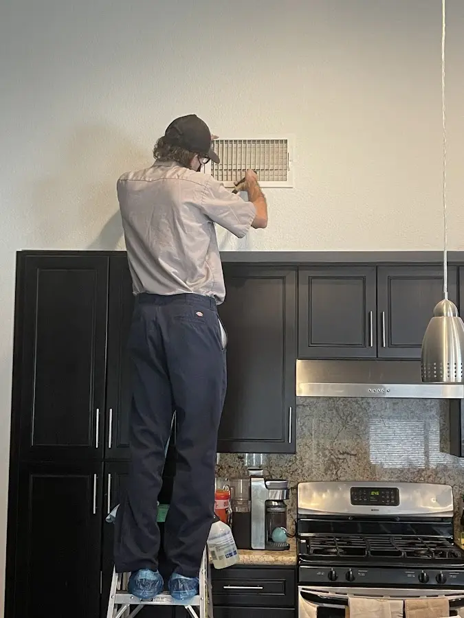 Technician inspecting an air vent during HVAC service in Palermo